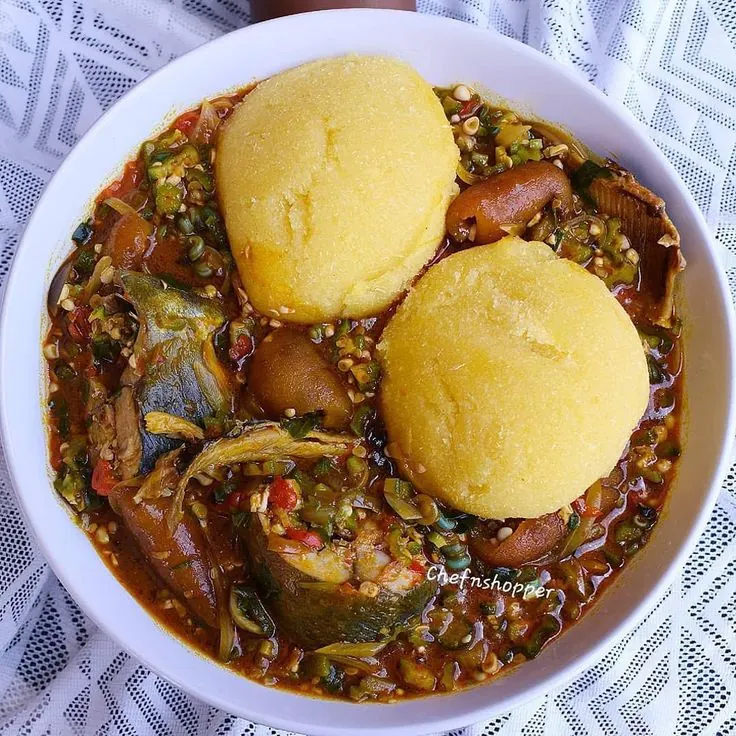 Banga soup with fish served alongside two wraps of fufu